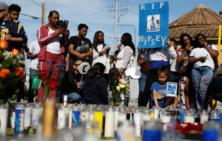 People gather around a makeshift memorial for Grammy-nominated rapper Nipsey Hussle who was shot and killed outside his clothing store in Los Angeles, California, U.S., April 1, 2019. REUTERS/Mario Anzuoni