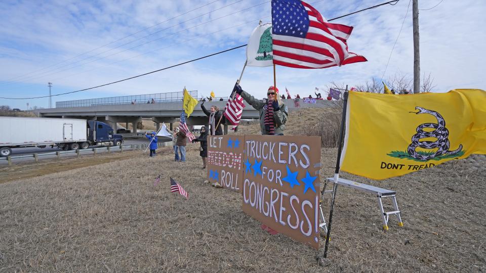 Supporters of a cross-country trucker's convoy gather at the St. Rt. 142 bridge over I-70 in West Jefferson on Thursday. Several hundred people gathered along different freeway overpasses along the interstate west of Columbus.