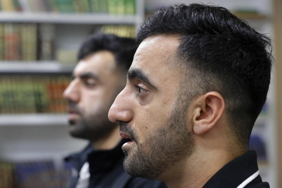 Brothers Samiullah Safi, left, and Abdul Wasi Safi speak during an interview after Friday prayers at the Al-Noor Society Mosque in Houston, on April 7, 2023. Abdul, who had suffered injuries while assisting the U.S. military in Afghanistan during the war, has recently arrived in Houston after being detained for months, but has no documentation allowing him to begin a normal life with his brother. (AP Photo/Michael Wyke)