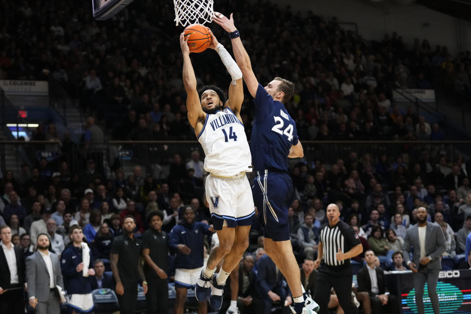 Villanova's Caleb Daniels, left, goes up for a shot against Xavier's Jack Nunge during the second half of an NCAA college basketball game, Saturday, Jan. 7, 2023, in Villanova, Pa. (AP Photo/Matt Slocum)