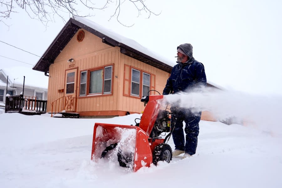 Ron Cook uses a snow blower to clear snow from his driveway in Sioux City, Iowa, Friday, Jan. 12, 2024. (AP Photo/Carolyn Kaster)