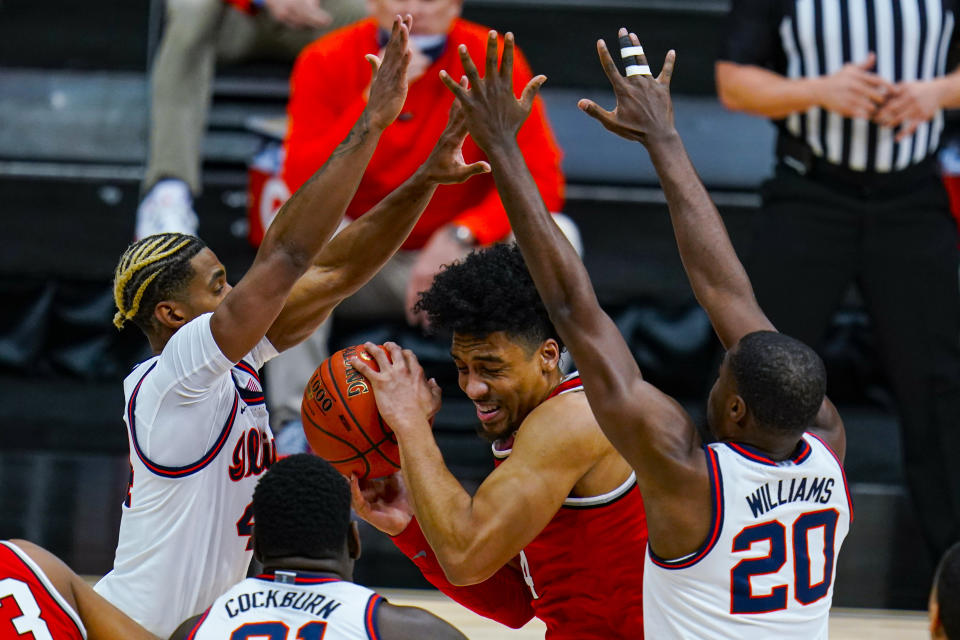 Ohio State forward Justice Sueing, center, is trapped between Illinois forward Zach Griffith, left, and guard Da'Monte Williams, right, in an NCAA college basketball championship game at the Big Ten Conference tournament in Indianapolis, Sunday, March 14, 2021. (AP Photo/Michael Conroy)