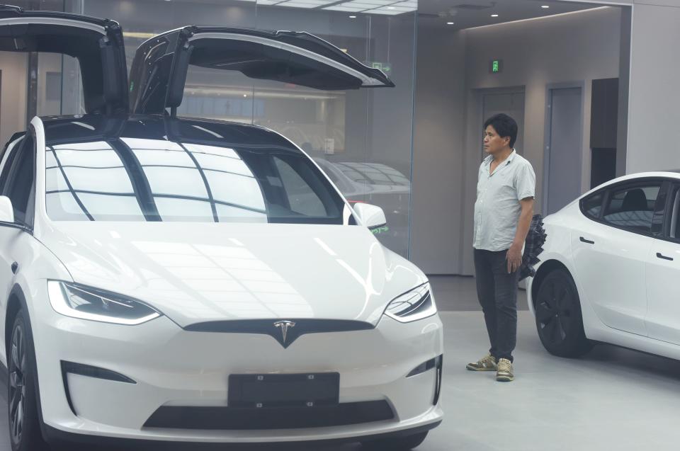 HANGZHOU, CHINA - JUNE 04 2024: A man looks at Tesla electric cars displayed in a shopping mall in Hangzhou in east China's Zhejiang province. (Photo credit should read LONG WEI / Feature China/Future Publishing via Getty Images)