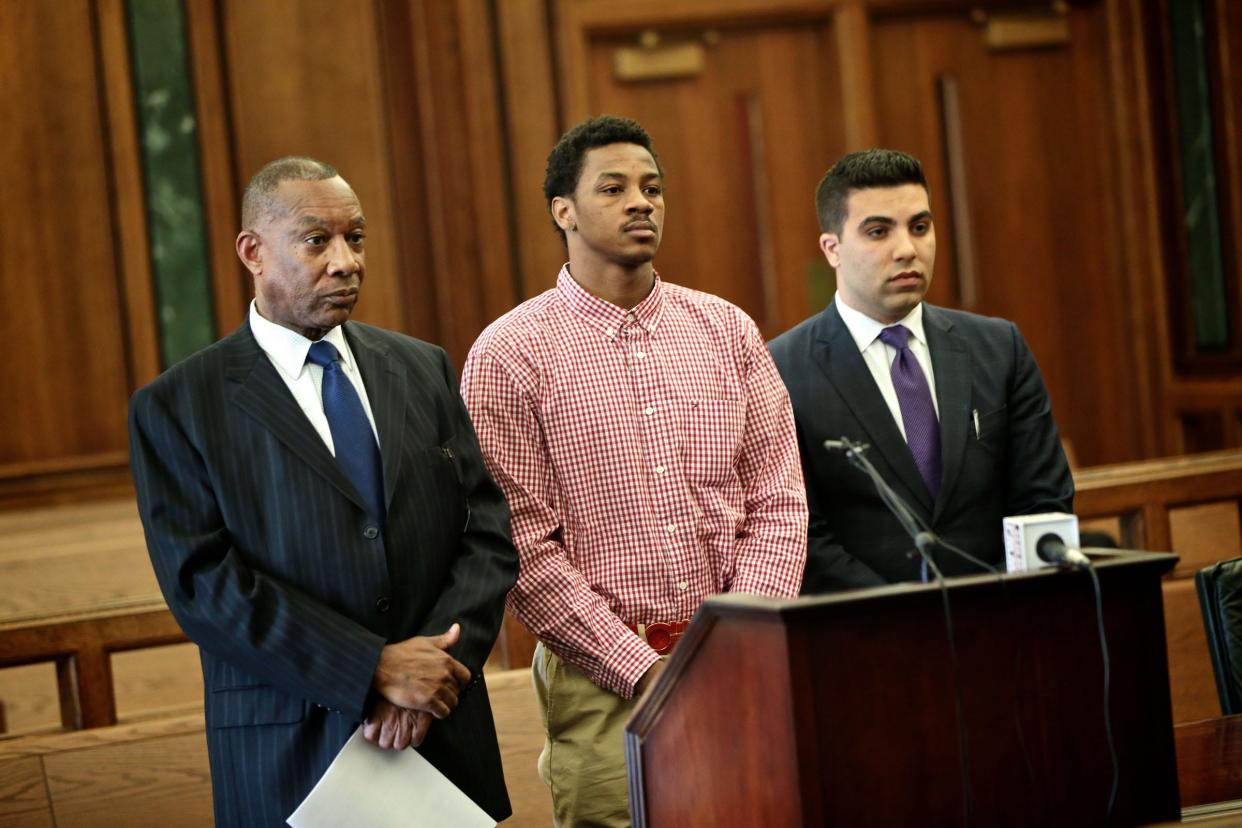 Former Michigan State basketball star Keith Appling, center, stands alongside his attorneys, Cyril C. Hall, left, and Amir I. Makled, during an arraignment May 4, 2016, in Dearborn.