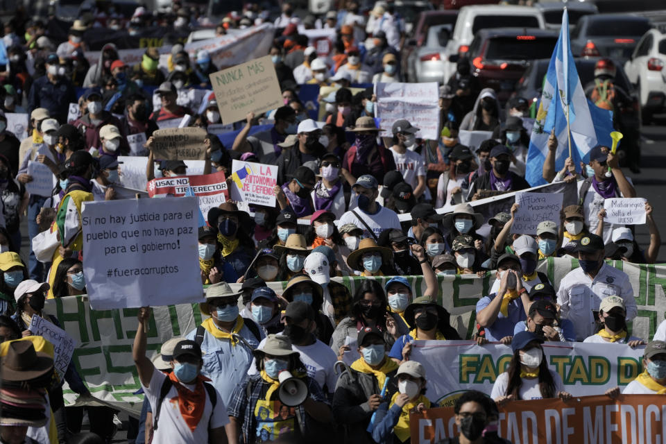 People march to protest against government of President Alejandro Giammattei in Guatemala City, Thursday, Aug. 11, 2022. Student and peasant sectors called for the march to protest everything from government corruption to the high cost of living. The sign at left reads in Spanish "If there's no justice for the people, there is no peace for the government! Get the corrupts out." (AP Photo/Moises Castillo)