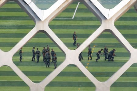 Chinese soldiers practice detaining a person on the grounds of the Shenzhen Bay Sports Center in Shenzhen across the bay from Hong Kong