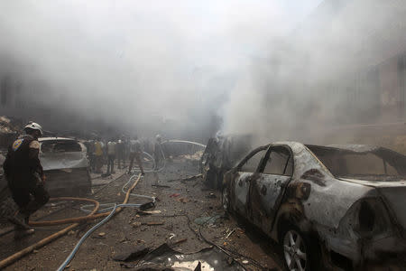 Smoke rises over a damaged site as Civil Defence members try to put out a fire after an airstrike on al-Jalaa street in the rebel held city of Idlib, Syria. REUTERS/Ammar Abdullah