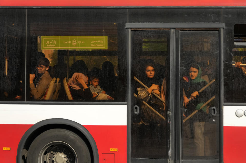 Passengers use a BRT bus in downtown Tehran, Iran, Sunday, April 14, 2024. Israel on Sunday hailed its air defenses in the face of an unprecedented attack by Iran, saying the systems thwarted 99% of the more than 300 drones and missiles launched toward its territory. (AP Photo/Vahid Salemi)