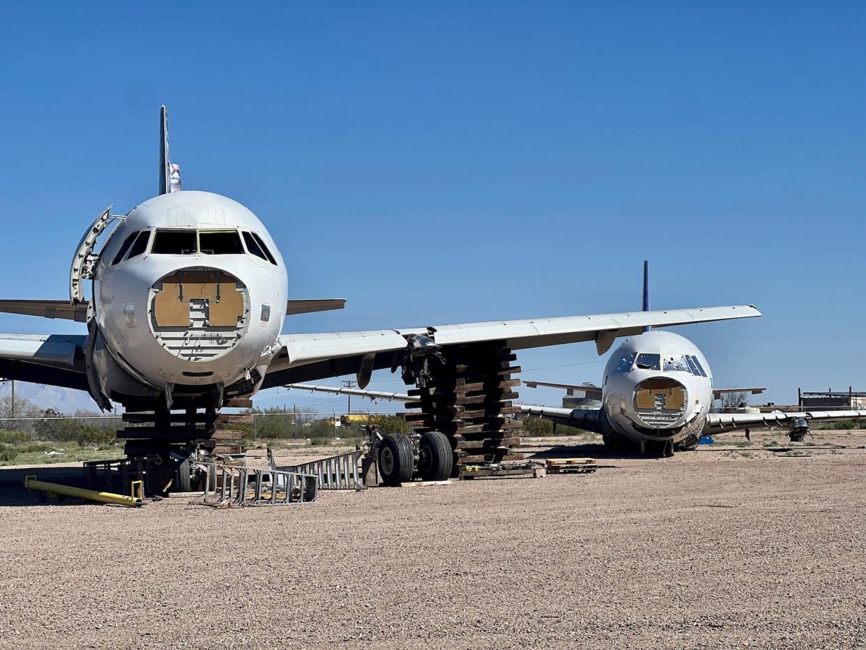 Two aircraft in reclamation with their landing gear already salvaged.