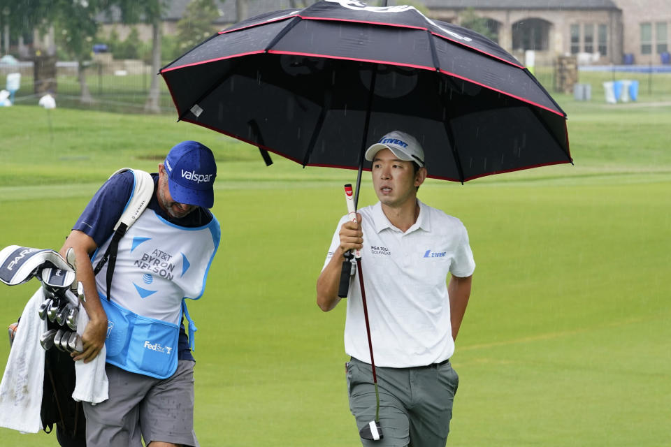 S.Y. Noh, of South Korea, uses an umbrella to keep dry during the first round of the Byron Nelson golf tournament in McKinney, Texas, Thursday, May 11, 2023. (AP Photo/LM Otero)