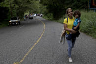 Honduran migrant Mary Dominguez, 27, carries her two-year-old son Dominic during a caravan of hundreds of Honduras migrants making their way to the U.S., as the group leaves Esquipulas, Guatemala, Tuesday, Oct. 16, 2018. U.S. President Donald Trump threatened on Tuesday to cut aid to Honduras if it doesn’t stop the impromptu caravan of migrants, but it remains unclear if governments in the region can summon the political will to physically halt the determined border-crossers. (AP Photo/Moises Castillo)