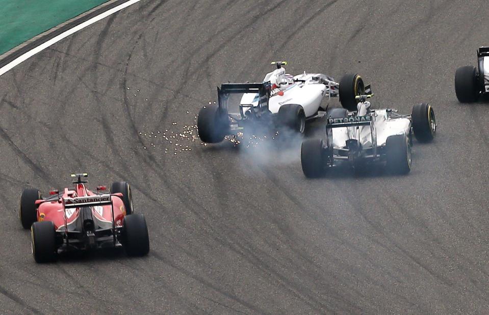 Williams driver Felipe Massa of Brazil, center left, and Mercedes driver Nico Rosberg of Germany, right, collide into turn one at the start of the Chinese Formula One Grand Prix at Shanghai International Circuit in Shanghai, Sunday, April 20, 2014. (AP Photo/Eugene Hoshiko)