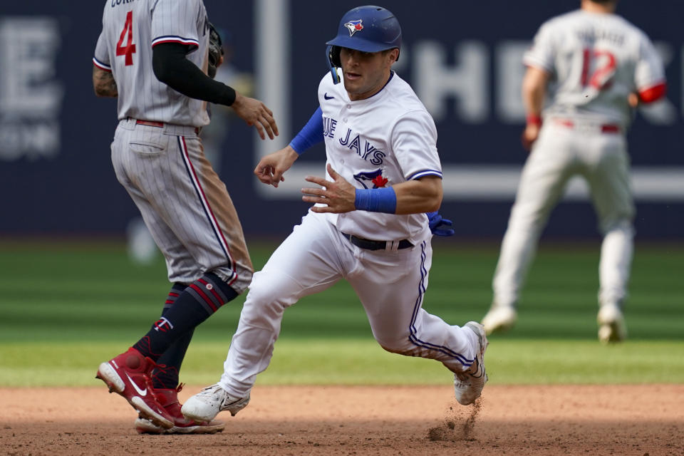 Toronto Blue Jays Daulton Varsho (25) runs from first to third base on an RBI single by Toronto's Santiago Espinal during the ninth inning of a baseball game, Saturday, June 10, 2023, in Toronto. (Arlyn McAdorey/The Canadian Press via AP)