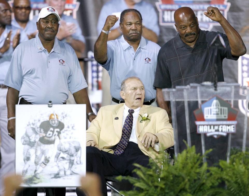 Pro Football Hall of Fame running backs (from left) Leroy Kelly, Bobby Mitchell and Jim Brown brought Gene Hickerson (front) onto the stage during Hickerson's enshrinement into the Hall of Fame at Fawcett Stadium on Aug. 4, 2007 in Canton. Hickerson, unable to take the stage himself due to poor health, was the lead blocker for Kelly, Mitchell and Brown in Cleveland.