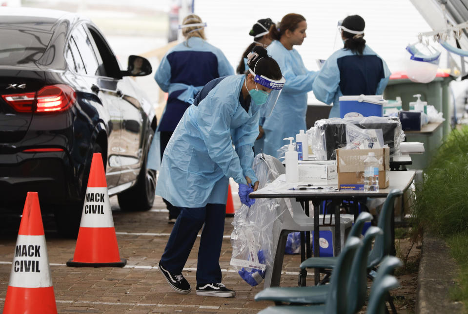 Staff prepare to test people at a drive through COVID-19 testing station at a beach in Sydney, Australia, Saturday, Dec. 19, 2020. Sydney's northern beaches will enter a lockdown similar to the one imposed during the start of the COVID-19 pandemic in March as a cluster of cases in the area increased to more than 40. (AP Photo/Mark Baker)