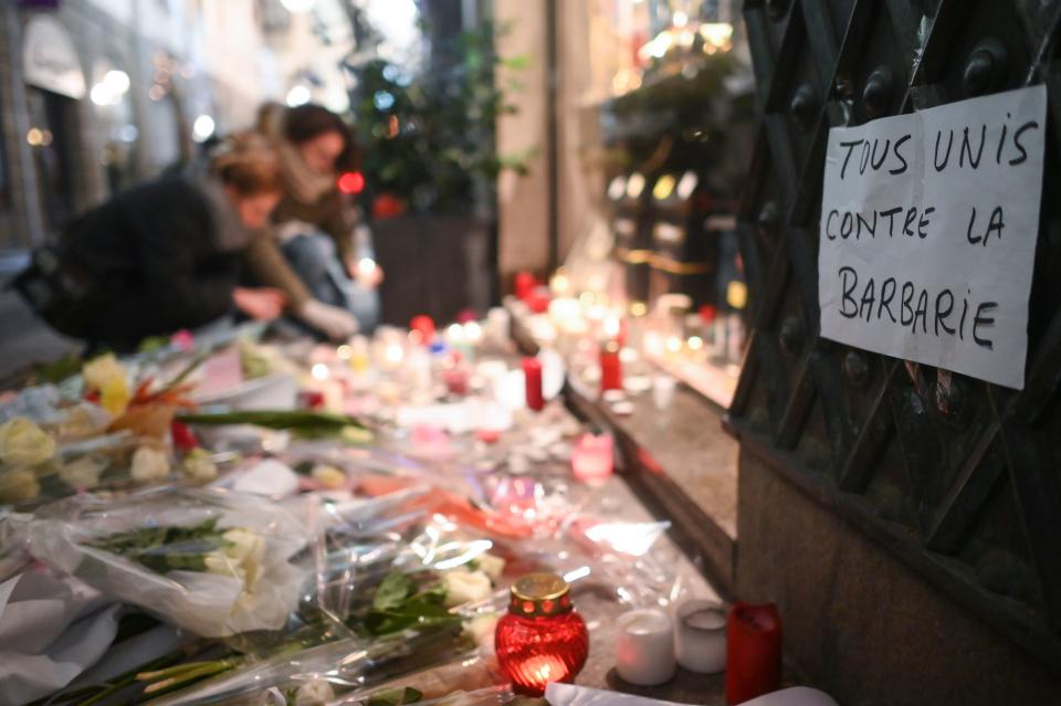 A sheet of paper reading “all together against barbarism” as people light candles on Dec. 13, 2018, in memory of the victims of the attack near the Christmas market of Strasbourg, in eastern France, on Dec.11, 2018. (Photo: Sebastien Bozon/AFP/Getty Images)