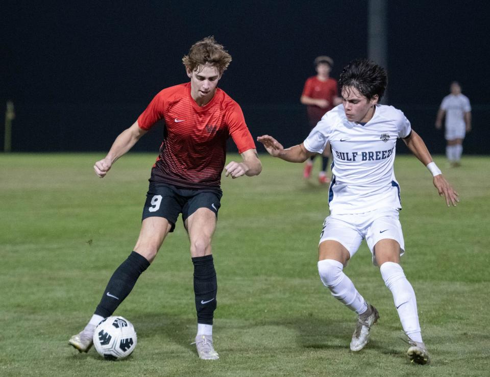 Jackson Clarke (9) tries to hold off Kyle Cosenza (5) while controlling the ball during the Gulf Breeze vs West Florida boys soccer game at Ashton Brosnaham Park in Pensacola on Wednesday, Dec. 7, 2022.