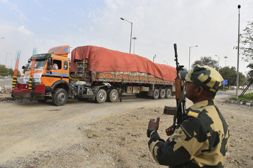 FILE - An Indian Border Security Force soldier guards as a truck carrying wheat from India moves to pass through the Attari-Wagah border between India and Pakistan, near Amritsar, India, Tuesday, Feb. 22, 2022. India's foreign ministry says it has sent off tons of wheat to Afghanistan to help relieve desperate food shortages, after New Delhi struck a deal with neighboring rival Pakistan to allow the shipments across the shared border. (AP Photo/Prabhjot Gill, File)