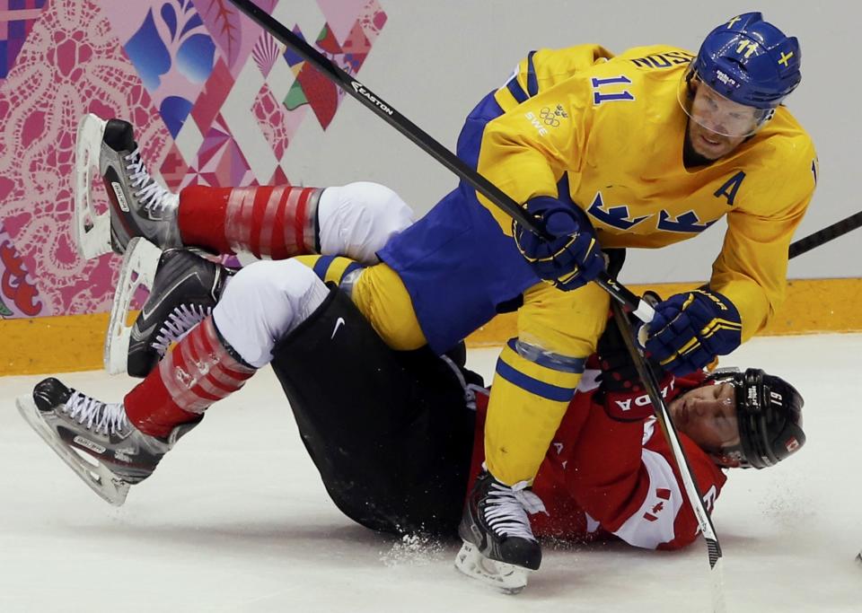 Canada's Rick Nash is checked by Sweden's Daniel Alfredsson (top) during the second period of their men's ice hockey gold medal match at the Sochi 2014 Winter Olympic Games February 23, 2014. REUTERS/Grigory Dukor (RUSSIA - Tags: OLYMPICS SPORT ICE HOCKEY TPX IMAGES OF THE DAY)