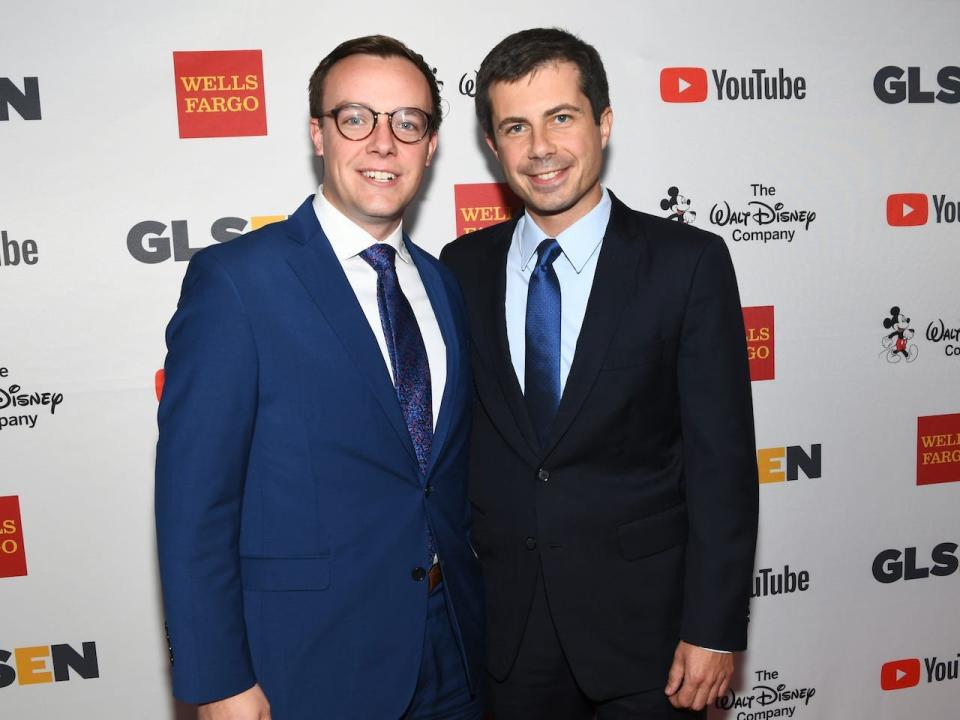 Chasten (left) and Pete Buttigieg in suits smiling at camera