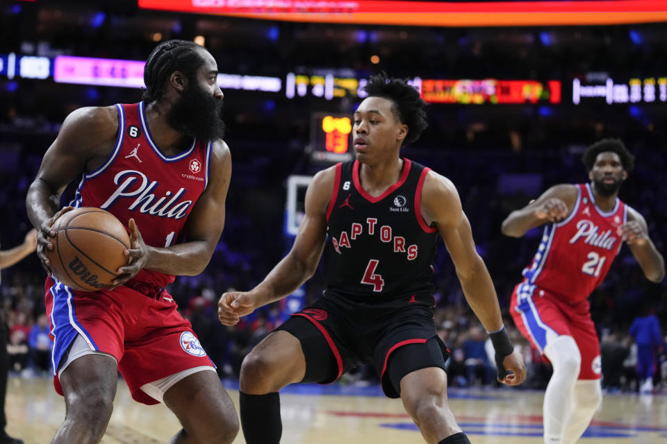 Philadelphia 76ers' James Harden, left, looks to pass the ball past Toronto Raptors' Scottie Barnes (4) during the second half of an NBA basketball game, Friday, March 31, 2023, in Philadelphia. (AP Photo/Matt Rourke)