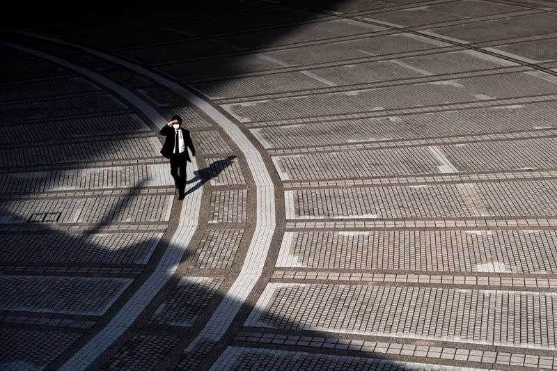 A man wearing a protective face mask, following an outbreak of the coronavirus, walks near the Tokyo Metropolitan Government building in Tokyo