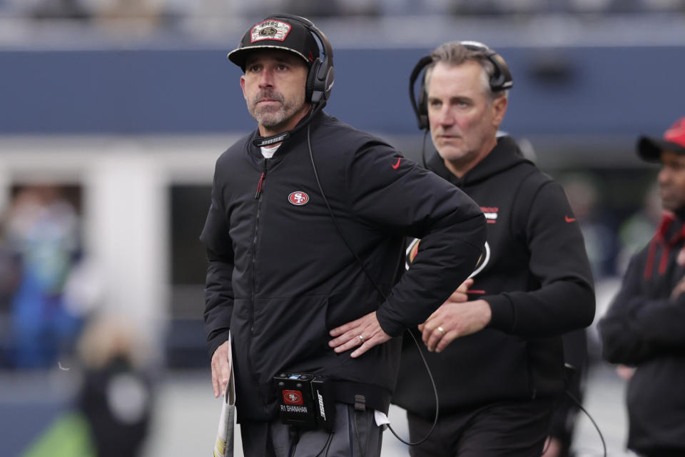 San Francisco 49ers Kyle Shanahan, left, stands on the sideline during the first half of an NFL football game against the Seattle Seahawks, Sunday, Dec. 5, 2021, in Seattle. (AP Photo/John Froschauer)