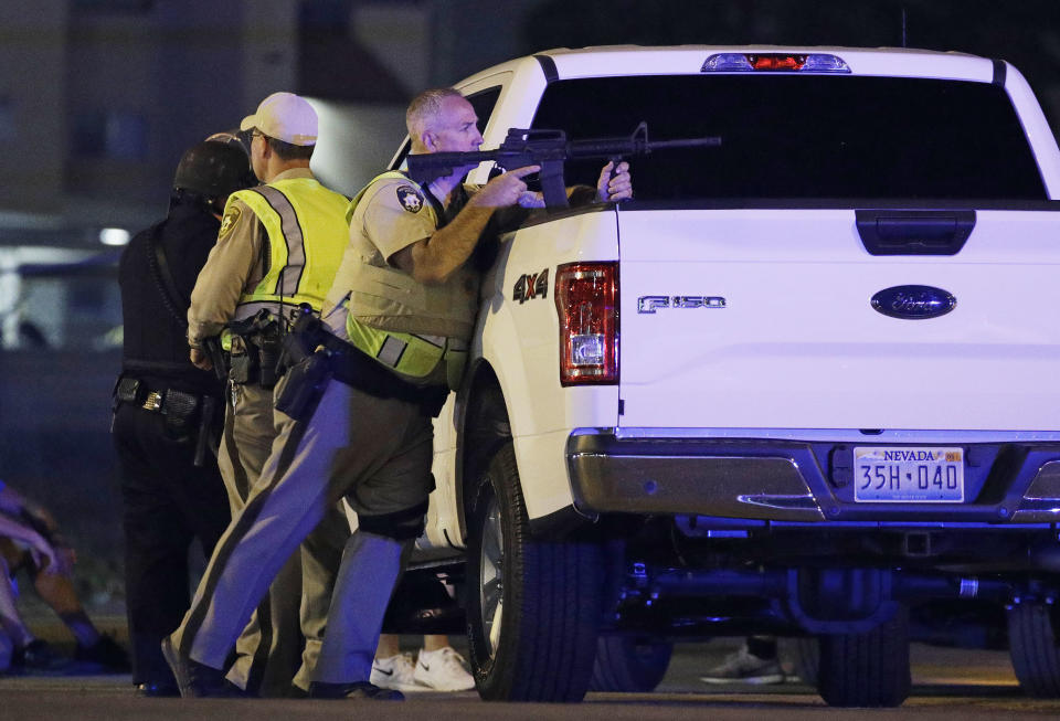 <p>A police officer takes cover behind a truck at the scene of a shooting near the Mandalay Bay resort and casino on the Las Vegas Strip, Oct. 1, 2017, in Las Vegas. Multiple victims were being transported to hospitals after a shooting late Sunday at a music festival on the Las Vegas Strip. (AP Photo/John Locher) </p>