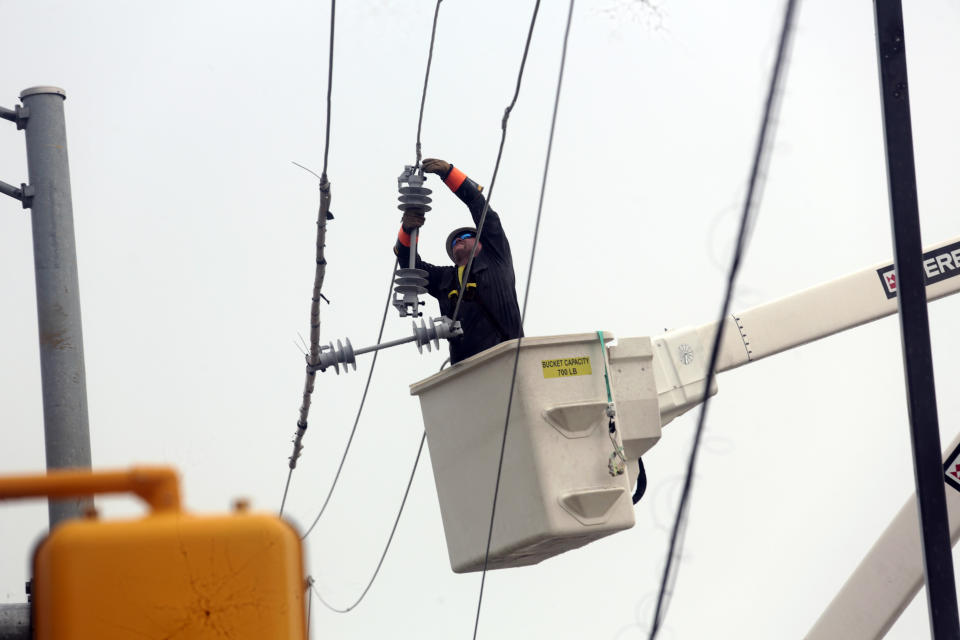 Utility crews work to restore electricity in Houston, Thursday, July 11, 2024. Officials say about 500,000 customers still won't have electricity into next week as wide outages from Hurricane Beryl persist. (AP Photo/Lekan Oyekanmi)