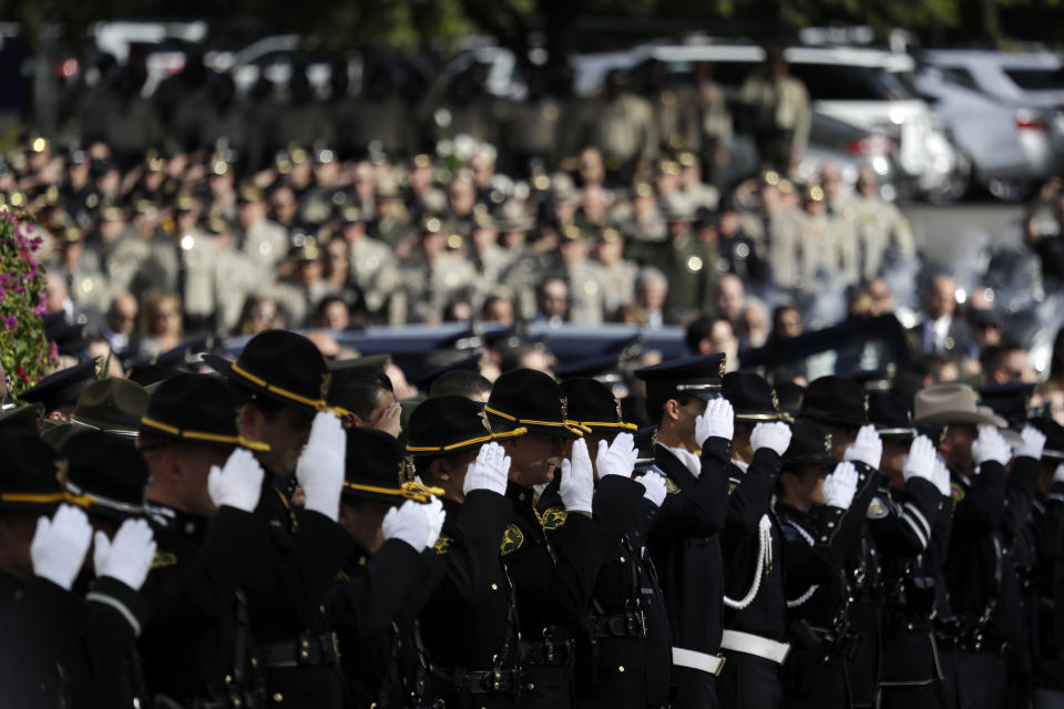 Law enforcement personnel salute as the casket of Ventura County Sheriff's Sgt. Ron Helus is carried out after a memorial service in Helus' honor at the Calvary Community Church Thursday, Nov. 15, 2018, in Westlake Village, Calif. (AP Photo/Marcio Jose Sanchez, Pool)