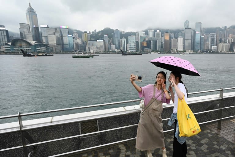 Unas turistas se fotografían en el paseo marítimo de Tsim Sha Tsui, en Hong Kong, el 1 de mayo de 2024 (Peter Parks)