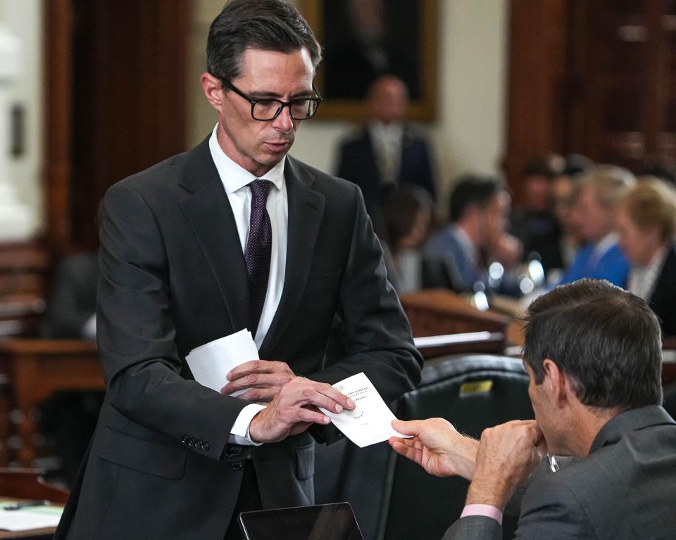 Texas Senate Sergeant-at-Arms Austin Osborn collects Sen. Nathan Johnson's vote on Article 1 in Ken Paxton's impeachment trial Saturday.