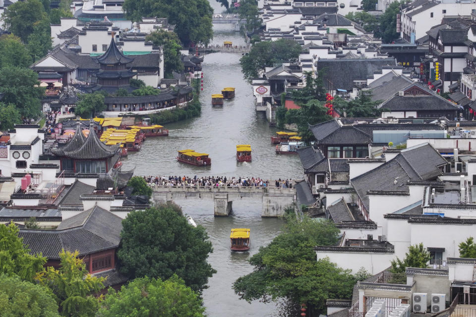 In this photo released by Xinhua News Agency, ferries carry passengers along the Fuzi Temple scenic area packed with tourists during a weeklong national holiday in Nanjing in east China's Jiangsu Province on Oct. 3, 2023. Tourism in China bounced back to pre-pandemic levels during a recent eight-day national holiday, giving a temporary boost to the nation's flagging economy. (Su Yang/Xinhua via AP)