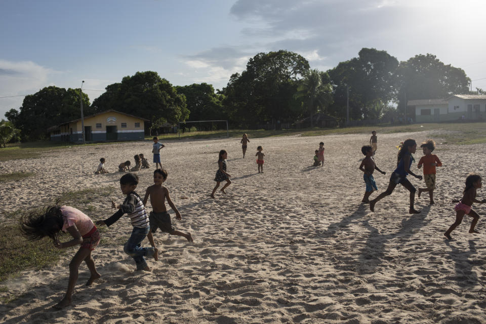 In this Sept. 3, 2019 photo, children play at a sandy soccer field during a meeting of Tembé tribes in Tekohaw indigenous reserve, Para state, Brazil. Classes had been canceled that day and life in the village seemed to have been put on hold so the Tembé tribes could debate the pros and cons of a plan that some hope will hold at bay the loggers and other invaders threatening the tribes of the Tembé. (AP Photo/Rodrigo Abd)