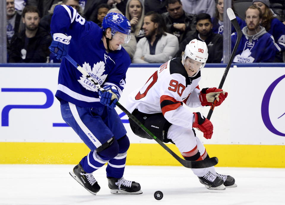 Toronto Maple Leafs defenseman Rasmus Sandin (38) and New Jersey Devils center Jesper Boqvist (90) vie for control of the puck during the third period of an NHL hockey game Tuesday, Jan. 14, 2020, in Toronto. (Frank Gunn/The Canadian Press via AP)