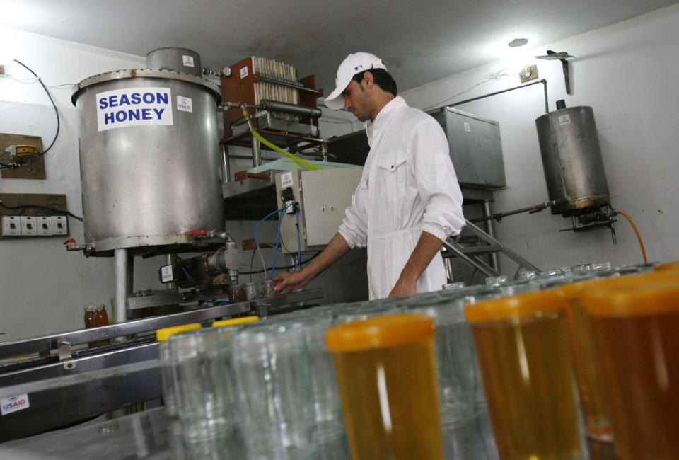 FILE - In this May 12, 2009 file photo, a worker fills jars with honey at a production company supported by the United States Agency for International Development, in Jalalabad, Afghanistan. Washington has poured over $143 billion into nation-building since 2002, according to the latest figures from the Special Inspector General for Afghanistan Reconstruction. (AP Photo/Rahmat Gul, File)