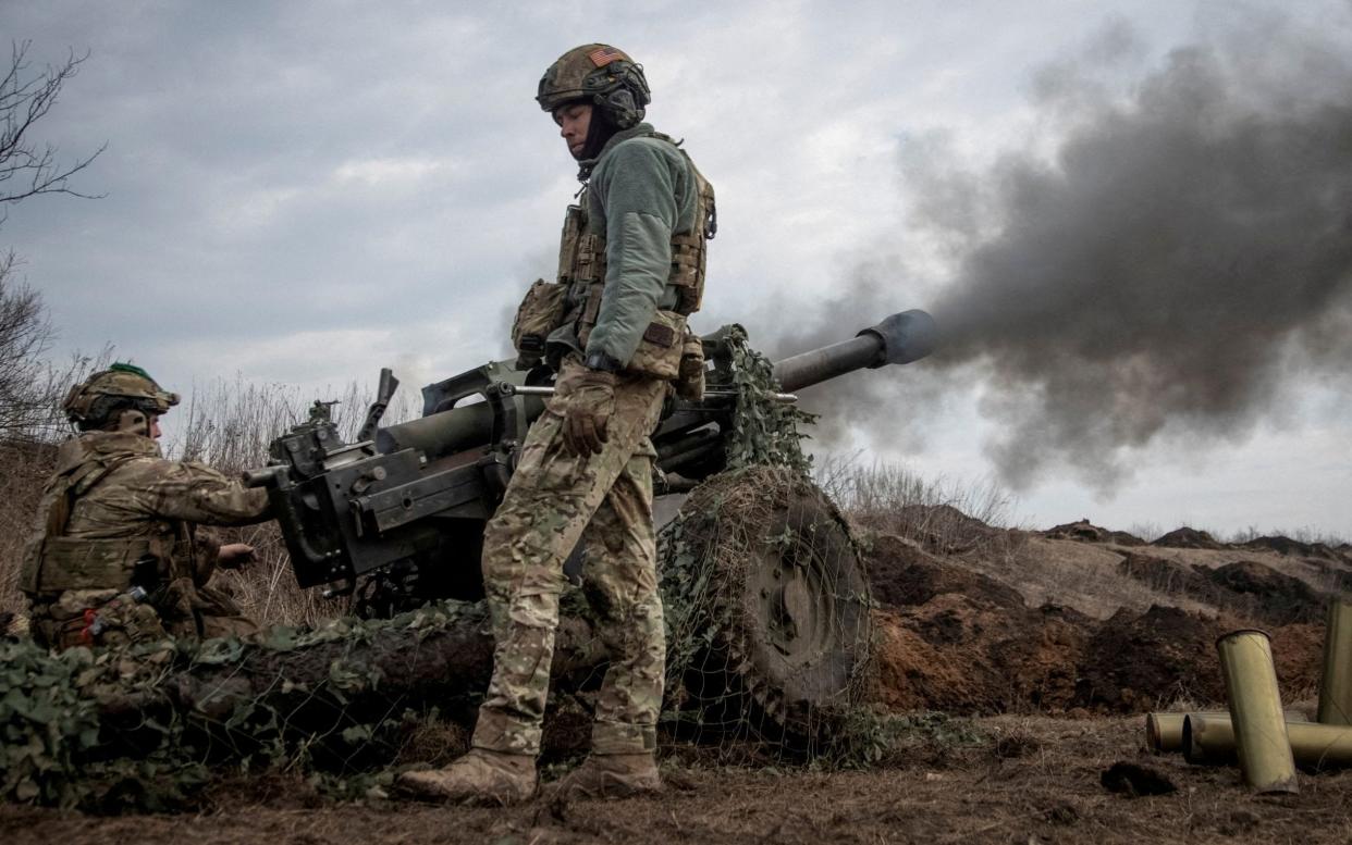 Ukrainian service members fire a howitzer M119 near the city of Bakhmut - REUTERS