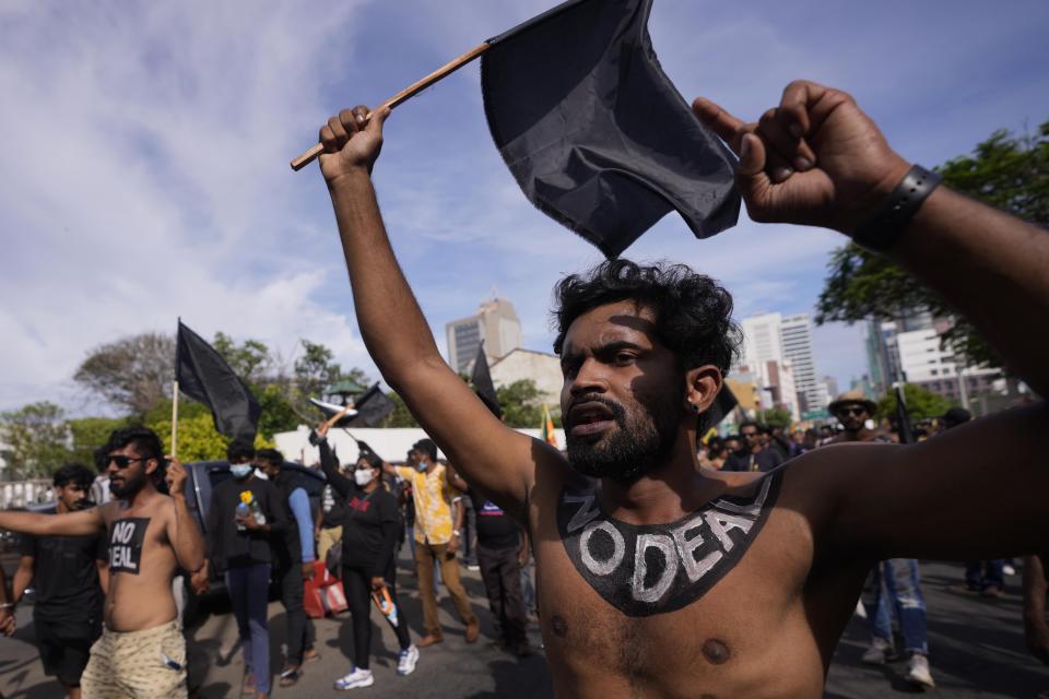 Protesters march near the president's official residence in Colombo, Sri Lanka, Saturday, May 28, 2022. Police fired tear gas and water canon on protesters who marched toward the president Gotabaya Rajapaksa's barricaded residence demanding his resignation. (AP Photo/Eranga Jayawardena)