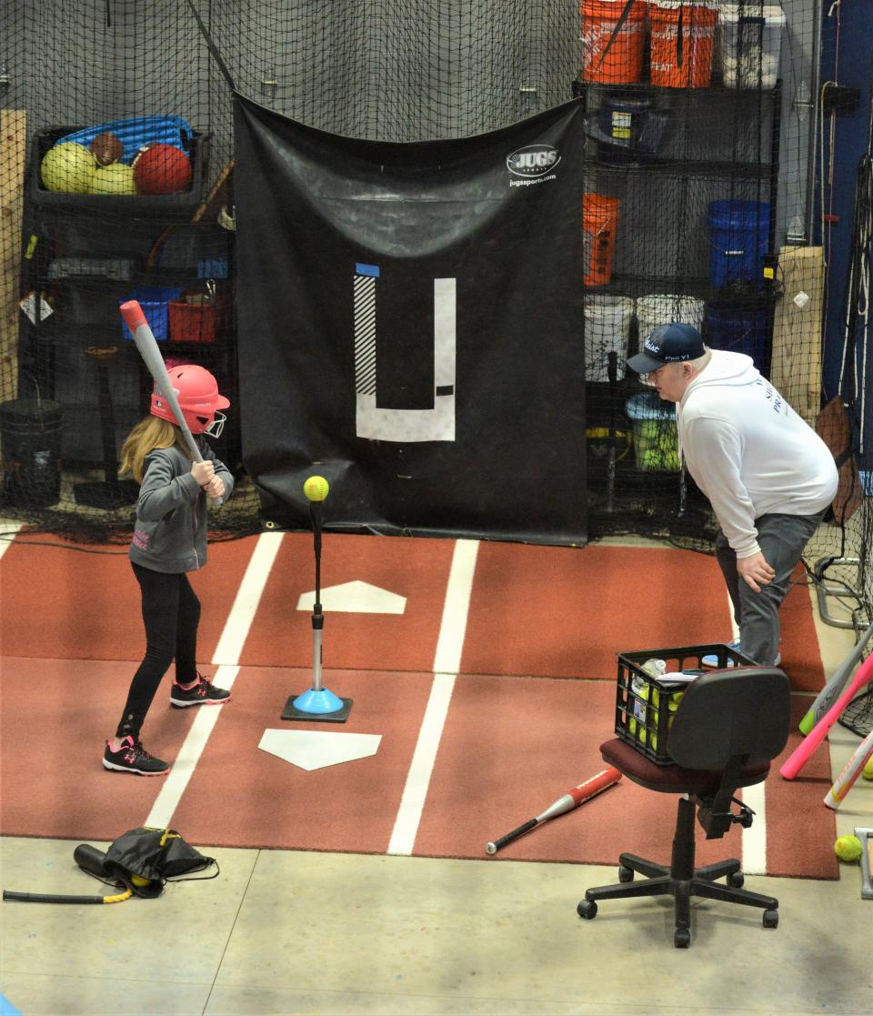 Michael Hague provides instruction to Chloe Unger at Elevate to Celebrate, which offers pitching, batting, fielding and throwing lessons, hitting and pitching assessments and cage rentals.