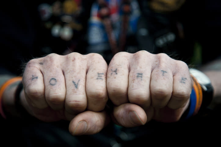 Close-up of a person's knuckles with tattoos reading "LOVE" on the left hand and "HATE" on the right hand