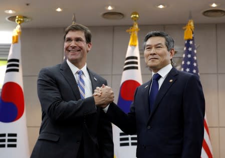 U.S. Defense Secretary Mark Esper and South Korean Defense Minister Jeong Kyeong-doo hold their hands ahead of a meeting at Defense Ministry in Seoul