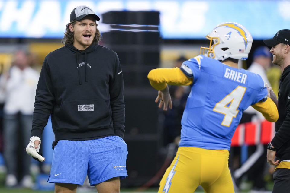 Los Angeles Chargers quarterback Justin Herbert watches quarterback Will Grier warm up before an NFL football game against the Buffalo Bills, Saturday, Dec. 23, 2023, in Inglewood, Calif. (AP Photo/Ryan Sun)