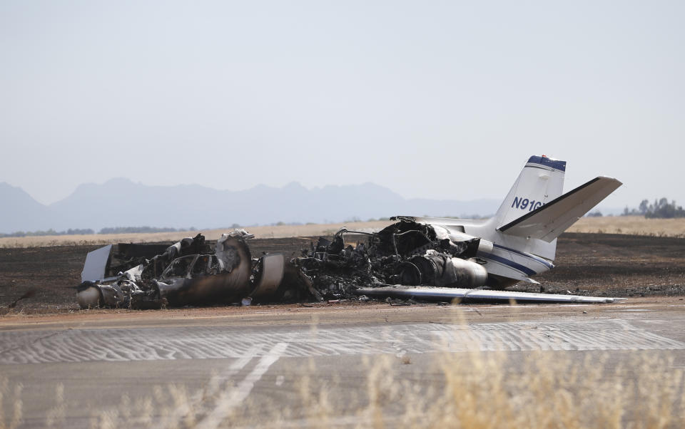 The burned out remains of a twin-engine Cessna Citation sits at the end of a runway after the pilot aborted the takeoff at the Oroville Airport in Oroville, Calif., Wednesday, Aug. 21, 2019. The plane carried two pilots and eight passengers, who all escaped injury. Firefighters were able to quickly control a grass fire that broke out and temporarily closed Highway 162. No cause of the crash has been listed. (AP Photo/Rich Pedroncelli)