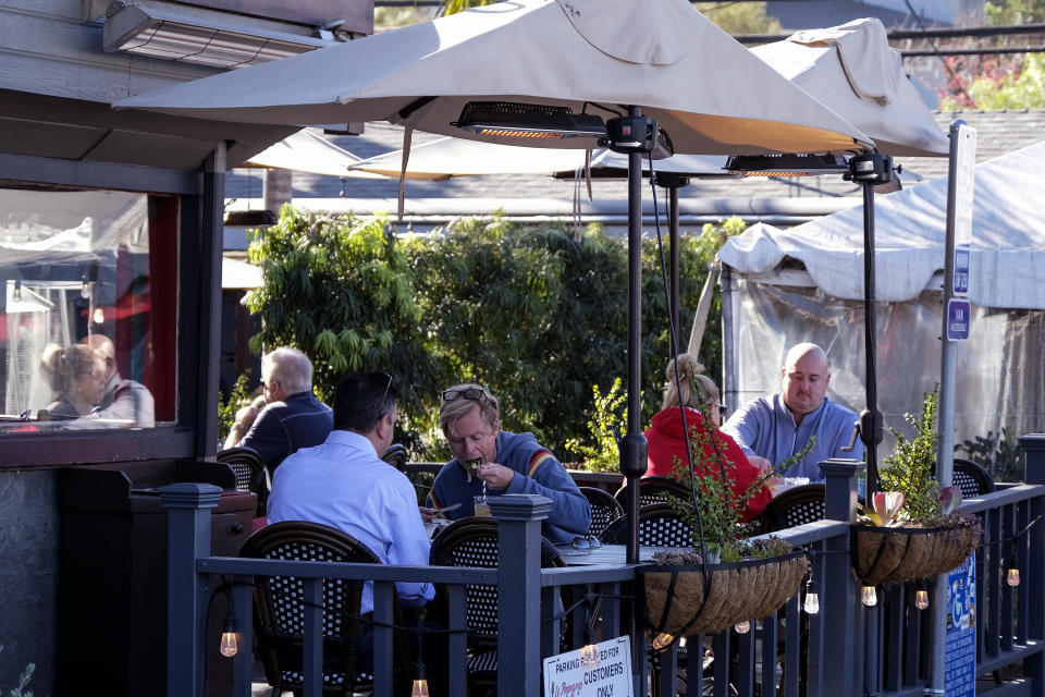 Patrons dine outside of a restaurant along the Coast Highway 101 in Encinitas, Calif., on Friday, Dec. 18, 2020. (AP Photo/Ringo H.W. Chiu)