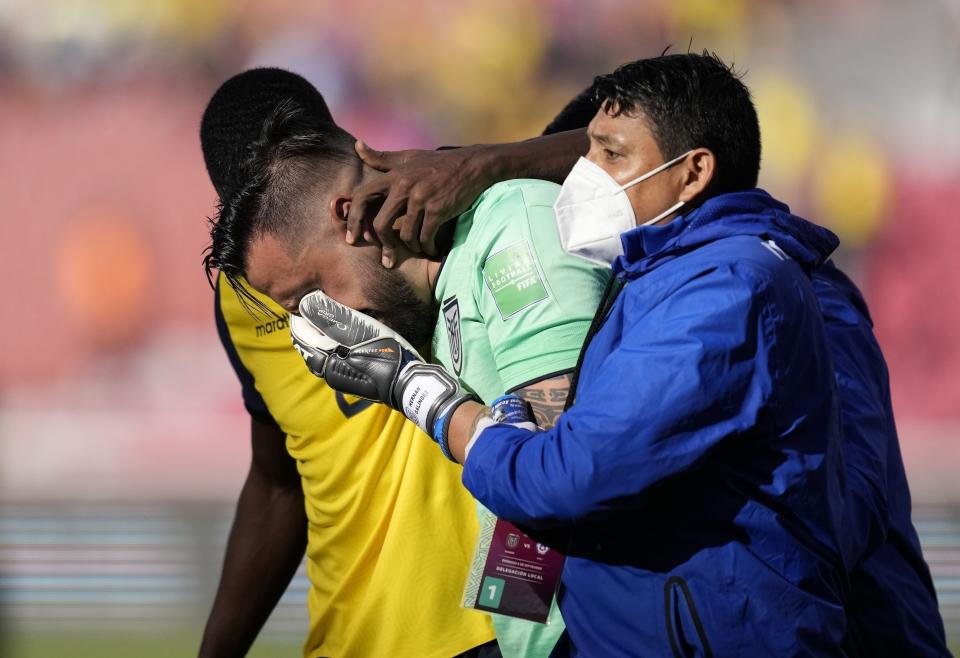 El arquero de Ecuador Hernán Galíndez (centro) se retira de la cancha lesionado durante el partido contra Chile por las eliminatorias de la Copa Mundial, el domingo 5 de septiembre de 2021, en Quito. (AP Foto/Dolores Ochoa, Pool)