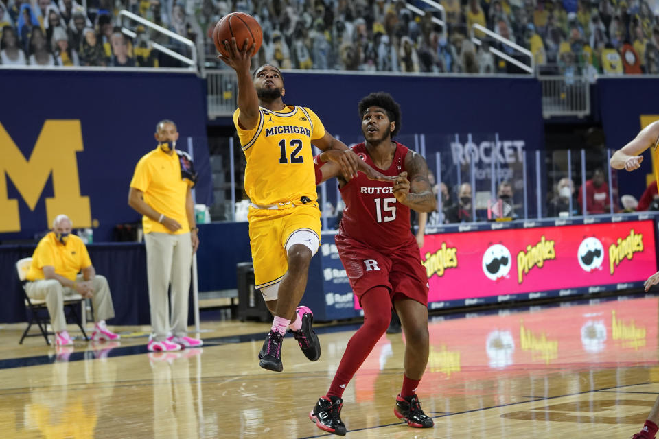 Michigan Wolverines guard Mike Smith (12) drives on Rutgers center Myles Johnson (15). (AP Photo/Paul Sancya)