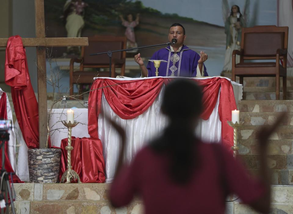 Father Camilo Monrroy celebrates Mass in Campohermoso, Colombia, Thursday, March 18, 2021, amid the new coronavirus pandemic. Father Monrroy says that constant prayer by the town’s citizens, especially to St. Roque, patron saint of the parish, the sick and epidemics, has made St. Roque the patron saint of COVID in the department of Boyaca. (AP Photo/Fernando Vergara)