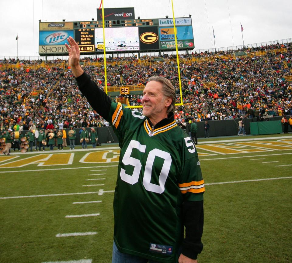 Jim Carter, former Green Bay Packers linebacker, waves to fans during a game against the Tampa Bay Buccaneers on Nov. 20, 2011, at Lambeau Field.