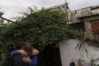 Nina Bilyk, right, is embraced by her friend, Olga Gurina, as she mourns the loss of her partner, Ivan Fartukh, at their home Saturday, Aug. 13, 2022, where he was killed in a Russian rocket attack last night in Kramatorsk, Donetsk region, eastern Ukraine. The strike killed three people and wounded 13 others, according to the mayor. The attack came less than a day after 11 other rockets were fired at the city. (AP Photo/David Goldman)