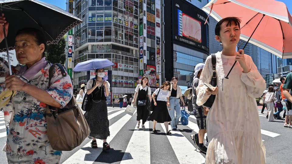 2023 年 7 月 30 日，东京，人们打着雨伞和遮阳伞来避暑。 - Richard A. Brooks/法新社，盖蒂图片社